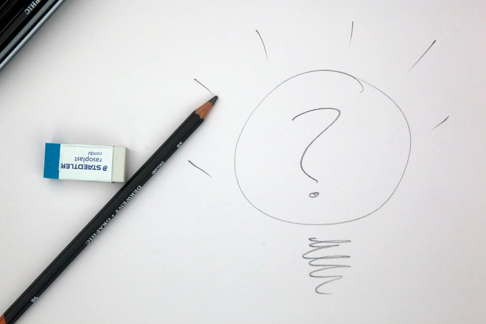 karta z narysowanym ołówkiem znakiem zapytania, praca kreatywna nad archetypem marki 
